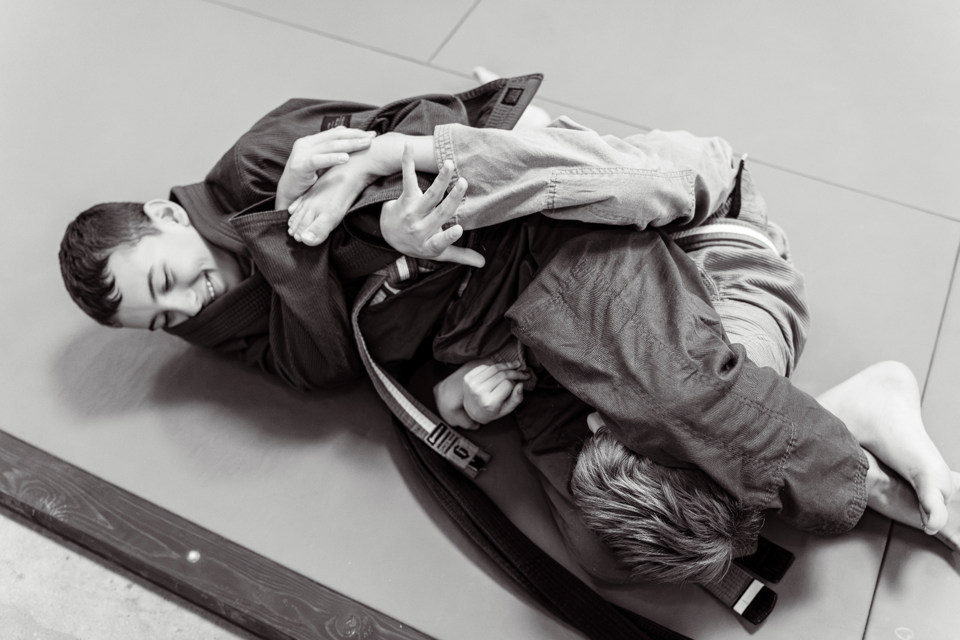 Young Brazilian Jiu-Jitsu students training together on the mats