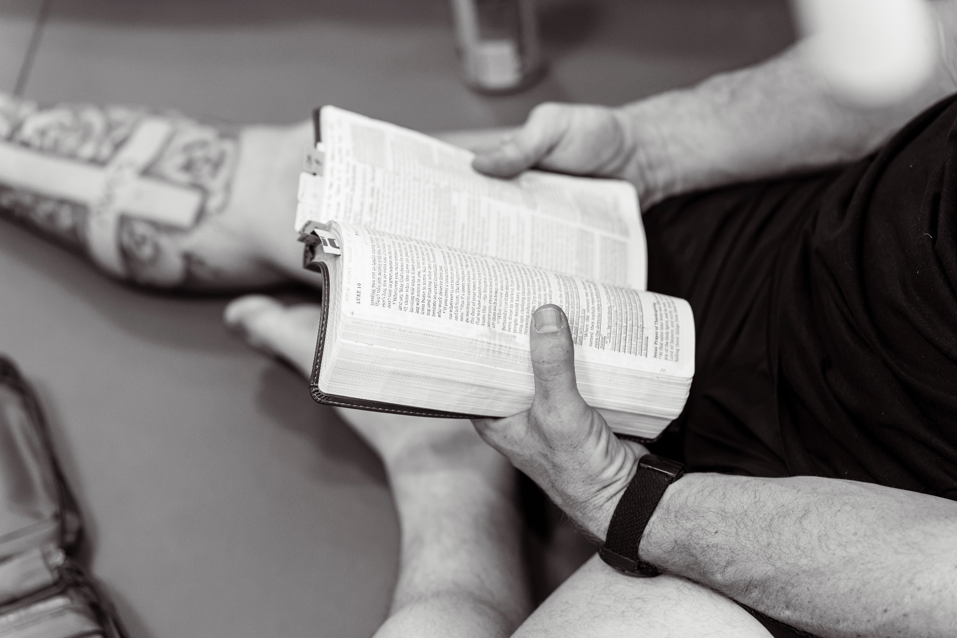 A grappler reading an open Bible on the mat between rounds